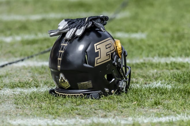 Purdue Boilermakers football helmet with football gloves on top