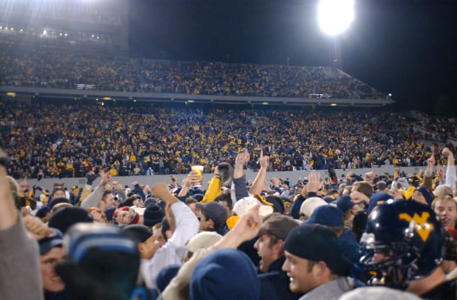 Fans quickly assemble on the field following the game.