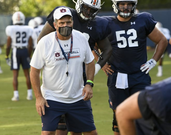 New Auburn offensive line coach Jack Bicknell Jr. works with the Tigers at practice last week, with Brahms (52) and Brodarious Hamm watching over his shoulder.