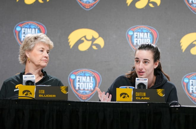 Iowa head coach Lisa Bluder listens as Iowa guard Caitlin Clark answers a 