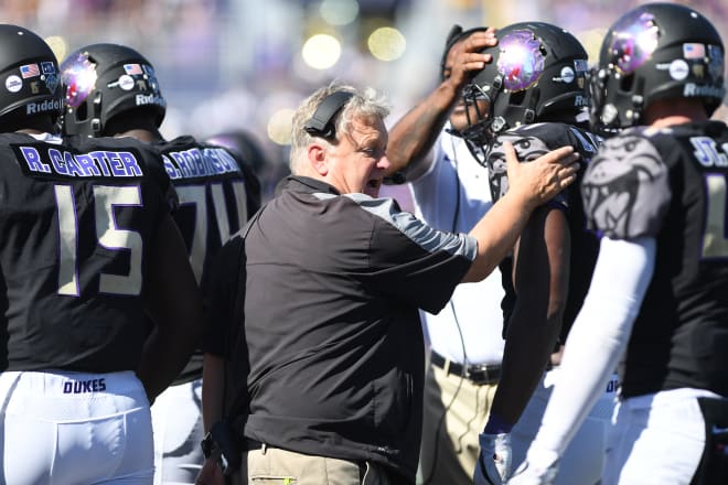 James Madison defensive coordinator Bob Trott congratulates his players as they come off the field during the Dukes' win over Maine last month in Harrisonburg.
