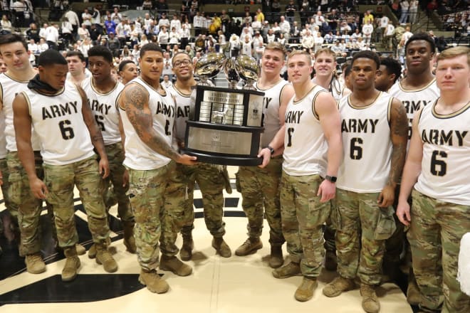 The Army football brotherhood showing off the hardware during halftime of Army-Navy men's hoops