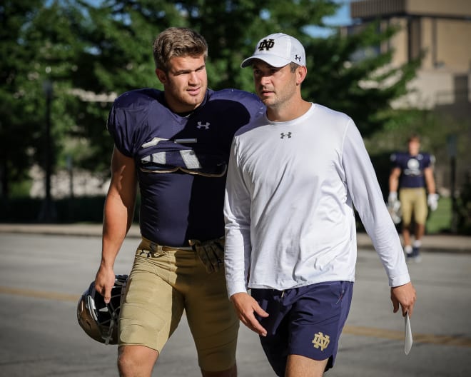 Irish junior Michael Mayer chats up offensive coordinator Tommy Rees on their way to a recent Notre Dame football practice.