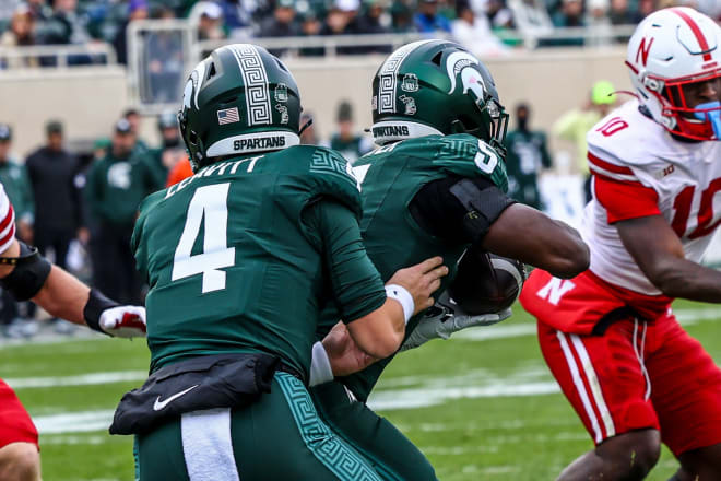 Michigan State's Sam Leavitt hands the ball off to Nate Carter during a game against the Nebraska Cornhuskers at Spartan Stadium in East Lansing, MI.