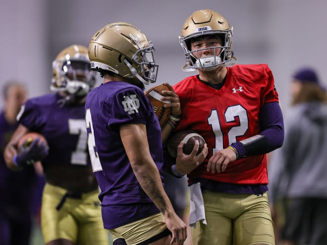 Chris Tyree, left, speaks to Notre Dame quarterback Tyler Buchner. Tyree, a long-time running back, practiced Wednesday as a wide receiver