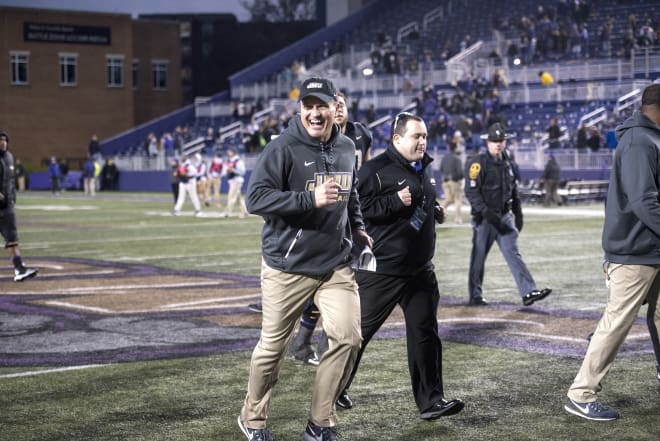 James Madison coach Mike Houston jogs toward his players following the Dukes' win over Stony Brook in the second round of the FCS playoffs earlier this month in Harrisonburg.