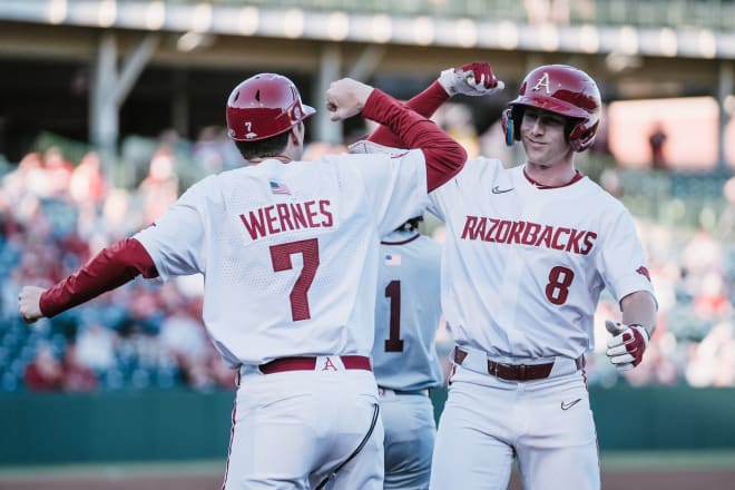 Arkansas' Jace Bohrofen celebrates an RBI single with first base coach Bobby Wernes during Tuesday's win 21-5 win over UALR.