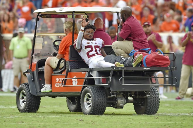 Florida State receiver Keyshawn Helton waves to teammates while being carted off the field last October at Clemson.