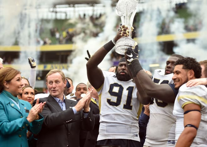 Gamble holds up the Keough-Naughton Trophy with Freddie Burden after the win over Boston College in Ireland