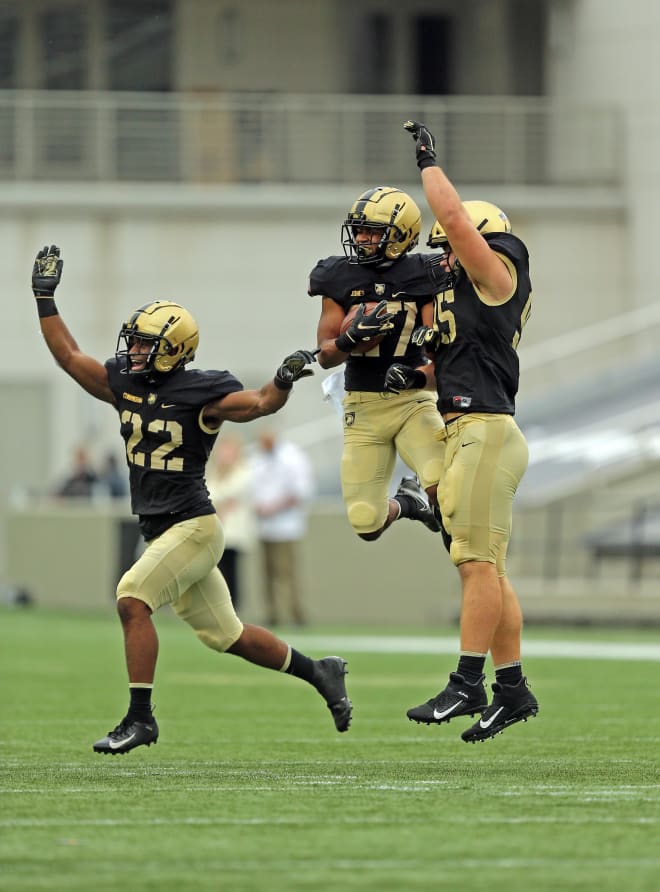 Cameron Jones (27) celebrates his interception with defensive back Cedrick Cunningham Jr. (22) and defensive lineman Nolan Cockrill (95) during the first half