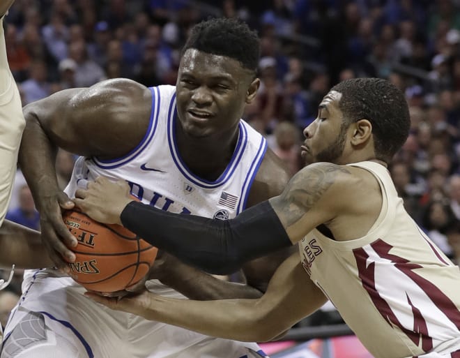 FSU guard David Nichols tries to take the ball from Duke star Zion Williamson.