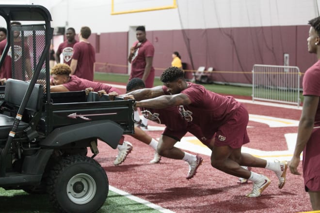 Defensive end Joshua Kaindoh and teammates push golf carts during Saturday's Lift for Life.