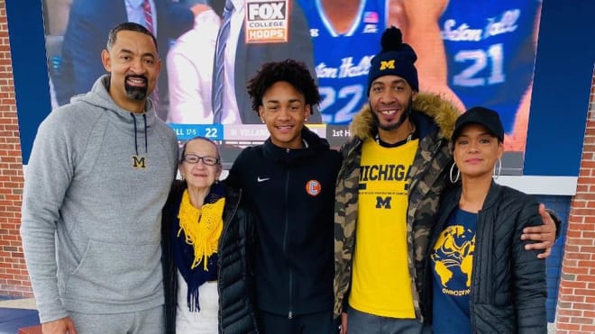 Michigan Wolverines basketball coach Juwan Howard and Fab Five teammate Jimmy King with Kobe Bufkin and family.