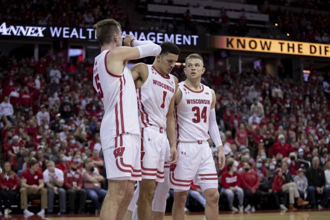 Johnny Davis is helped off the court by Brad Davison (34) and Tyler Wahl (5) after injuring his ankle Sunday against Nebraska.