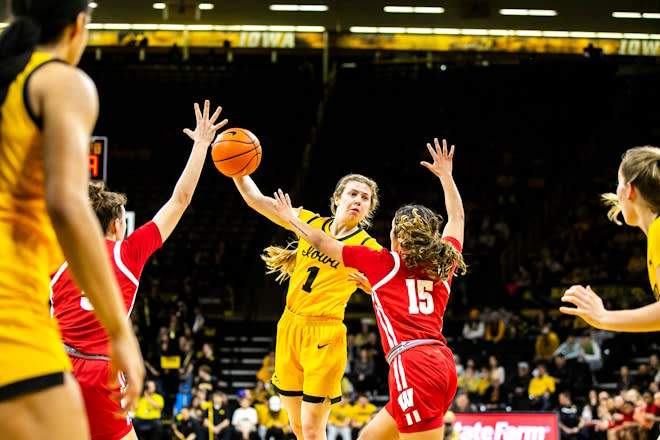 Iowa guard Molly Davis (1) passes the ball as Wisconsin guard Sania Copeland (15) defends during a NCAA Big Ten Conference women's basketball game, Wednesday, Feb. 15, 2023, at Carver-Hawkeye Arena in Iowa City, Iowa.