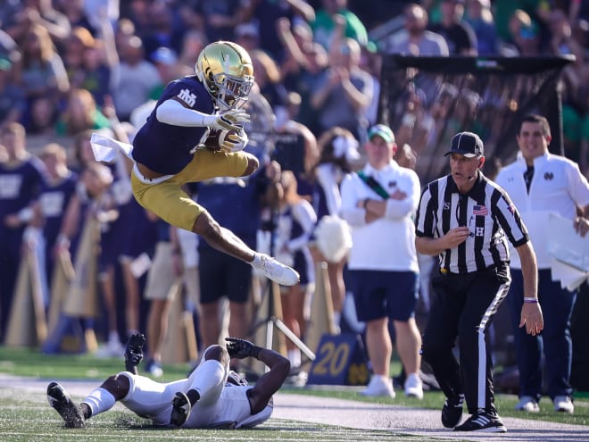 Junior cornerback Clarence Lewis (jumping) returns a fumble and hurdles a defender against UNLV.