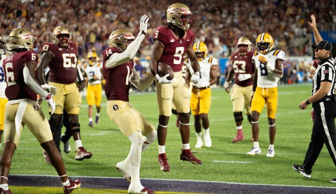 Lawrance Toafili celebrates with Johnny Wilson and teammates on Sunday.