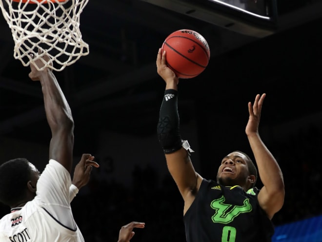 USF Bulls guard David Collins goes up for a layup against Cincinnati Bearcats forward Trevon Scott in the second half at Fifth Third Arena.