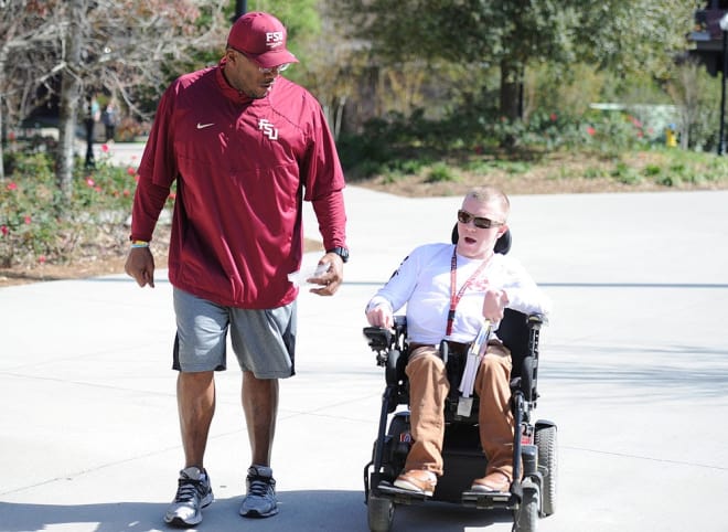 Payton Poulin rides to FSU practice this spring while talking with Jerry Johnson, a former Seminole player and current quality control assistant.