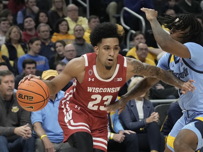 Wisconsin's Chucky Hepburn gets past Marquette's Sean Jones in the first half, a period where he scored 16 of his 19 points.