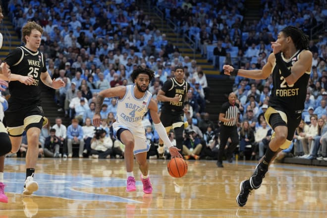 UNC's RJ Davis brings the ball up the court in between Wake Forest's Zach Keller, left, and Hunter Sallis. 