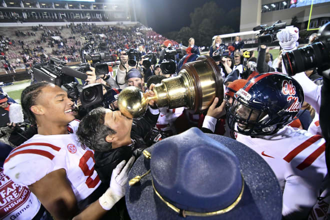 Former Ole Miss Rebels head coach Matt Luke kisses the Egg Bowl trophy after the game against the Mississippi State Bulldogs at Davis Wade Stadium. Mandatory Credit: Matt Bush-USA TODAY Sports