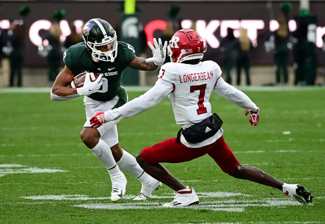 Michigan State Spartans wide receiver Keon Coleman (0) fends-off Rutgers Scarlet Knights defensive back Robert Longerbeam (7) for a first down at Spartan Stadium, Nov 12, 2022; East Lansing, Michigan.