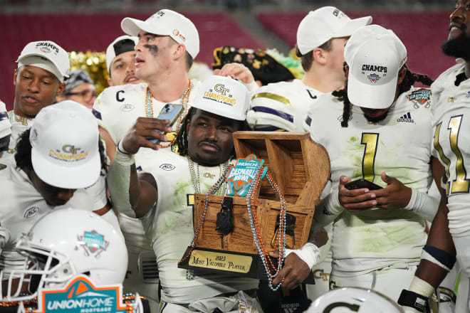 Tech players celebrate with the Gasparilla Bowl trophy