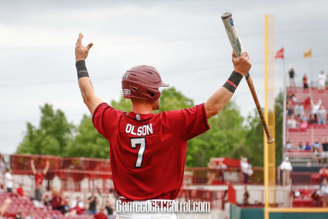Jacob Olson raises his hands as he watches Justin Row's home run clear the fence.