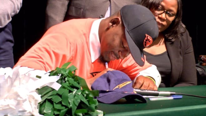 Turnier signs his NLI at a school ceremony