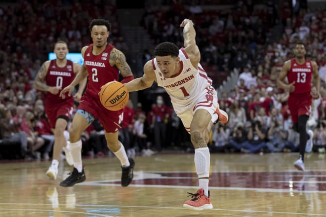 Johnny Davis starts to stumble as he drives to the hoop early in the second half against Nebraska. Trey McGowens (2) trails the play.