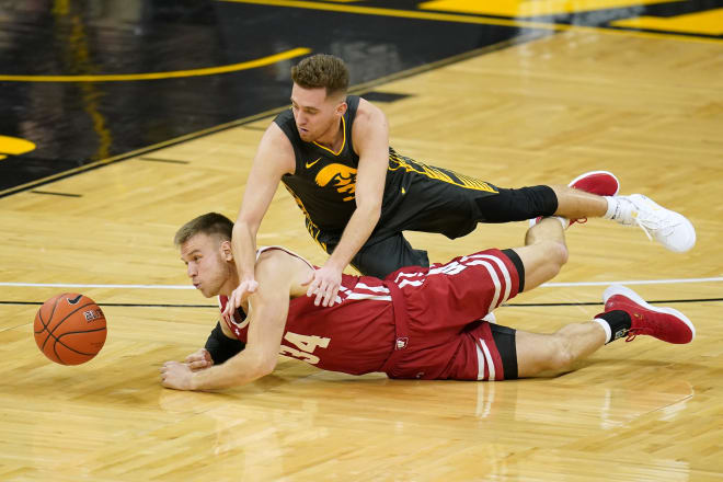 Wisconsin guard Brad Davison (34) fights for a loose ball with Iowa guard Jordan Bohannon during the first half of an NCAA co