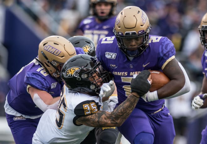 James Madison running back Latrele Palmer carries the ball and breaks a tackle during the Dukes' win over Towson last year at Bridgeforth Stadium.