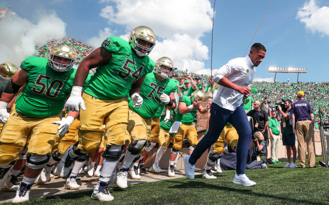 Irish head coach Marcus Freeman leads his team out of the Notre Dame Stadium tunnel onto the field.
