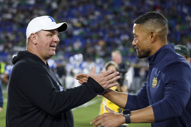 Two former Notre Dame defensive coordinators, Duke head coach Mike Elko (left) and ND's Marcus Freeman share a moment before Saturday night's Duke-ND game.