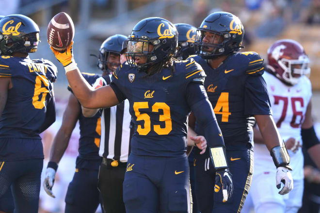 Kaleb Elarms-Orr holding the ball in a game against Washington State. 