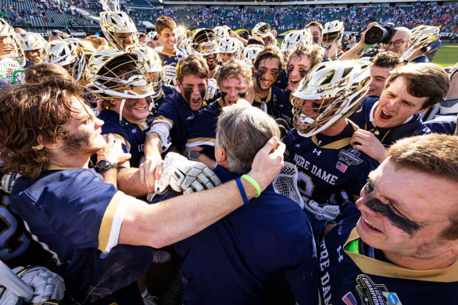 Notre Dame men's lacrosse coach Kevin Corrigan is swarmed by his players after the Irish knocked off Virginia, 13-12 in OT, Saturday in the NCAA Final Four.