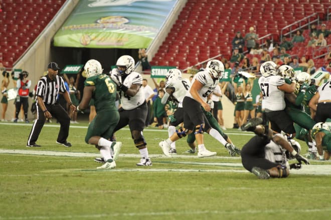 Memphis' Patrick Taylor runs for a gain while the USF player to the right is not held | Ben McCool, Running the Bulls