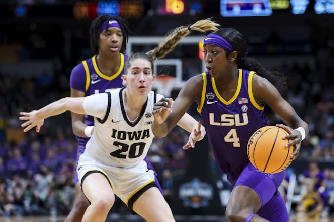 LSU Lady Tigers guard Flau'jae Johnson (4) drives to the basket against Iowa Hawkeyes guard Kate Martin (20) in the first half during the final round of the Women's Final Four NCAA tournament at the American Airlines Center. 