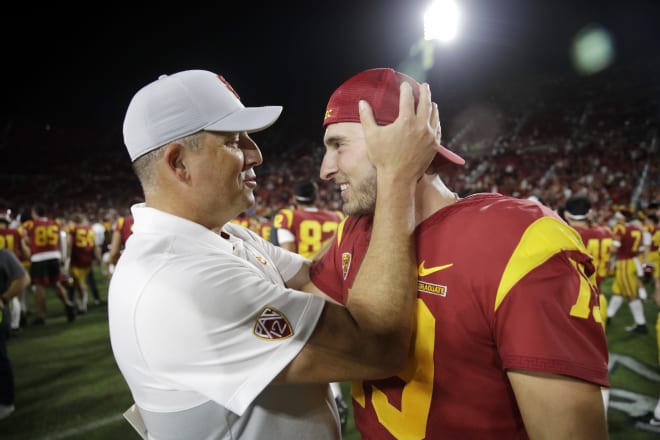 Coach Clay Helton, who welcomed Fink back to the team after he tested the NCAA transfer portal, shares a celebratory moment with his QB after the game.