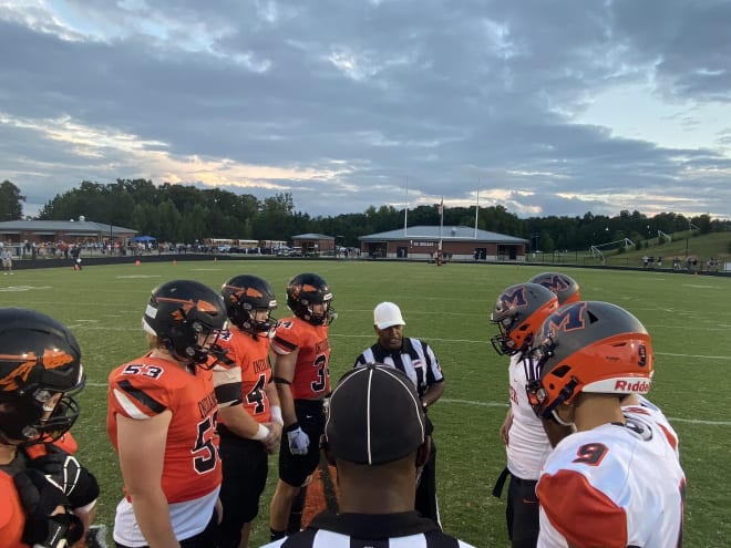 Powhatan and Manchester team captains meet at midfield for the coin toss (9/17/21)