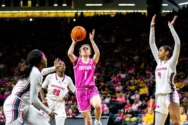 Iowa guard Molly Davis (1) makes a basket as Rutgers center Kassondra Brown, left, Erica Lafayette (20) and Antonia Bates, right, defend during a NCAA Big Ten Conference women's basketball game, Sunday, Feb. 12, 2023, at Carver-Hawkeye Arena in Iowa City, Iowa. 