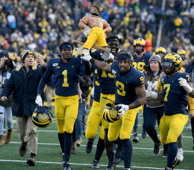 Michigan Wolverines football cornerback Ambry Thomas and wideout Donovan Peoples-Jones celebrate with the Paul Bunyan trophy. 