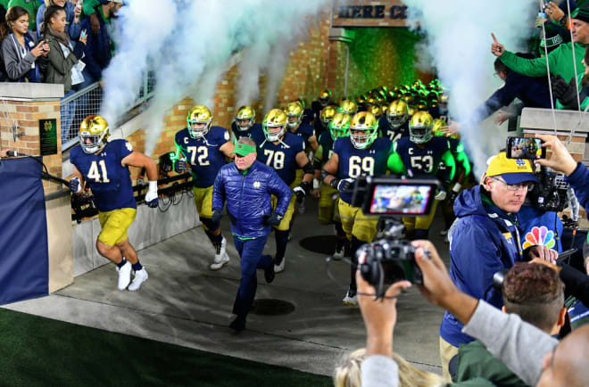 Notre Dame Head Coach Brian Kelly and team running out of tunnel (Andris Visockis)
