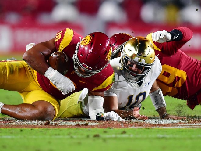 USC linebacker Ralen Goforth, left, recovers a fumble from Notre Dame quarterback Drew Pyne, in white.