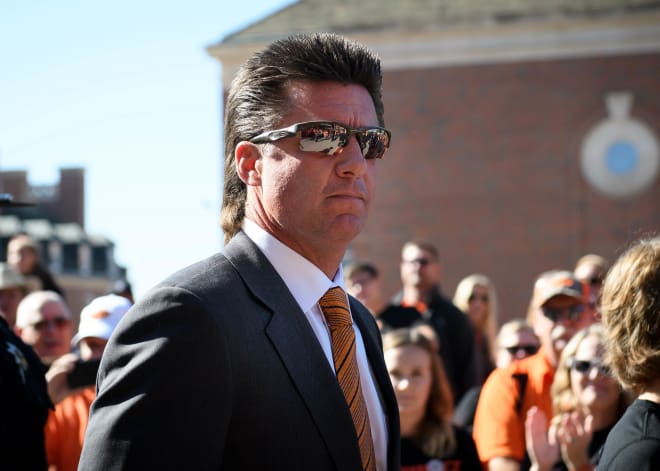 Magnificent Mike Gundy heads to the ring to face off against Ric Flair, The Undertaker or someone. God, that mullet is glorious. 
