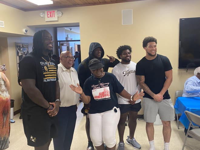 Darius Robinson and teammates Chad Bailey, Nathaniel Peat and Chuck Hicks pose for a picture with two members of Second Missionary Baptist Church. 
