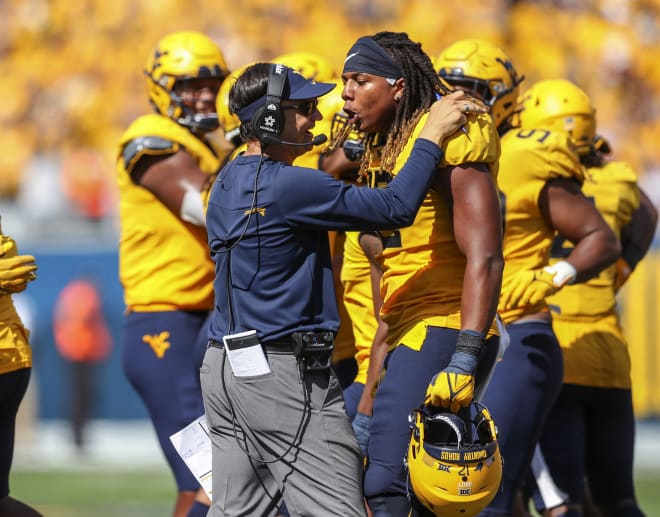 Taijh Alston (12) celebrates with West Virginia head coach Neal Brown against Virginia Tech.