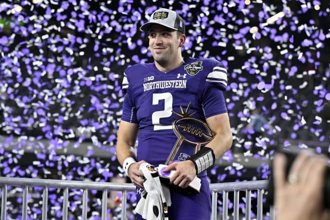 Ben Bryant holds his Las Vegas Bowl MVP Trophy as confetti rains down.