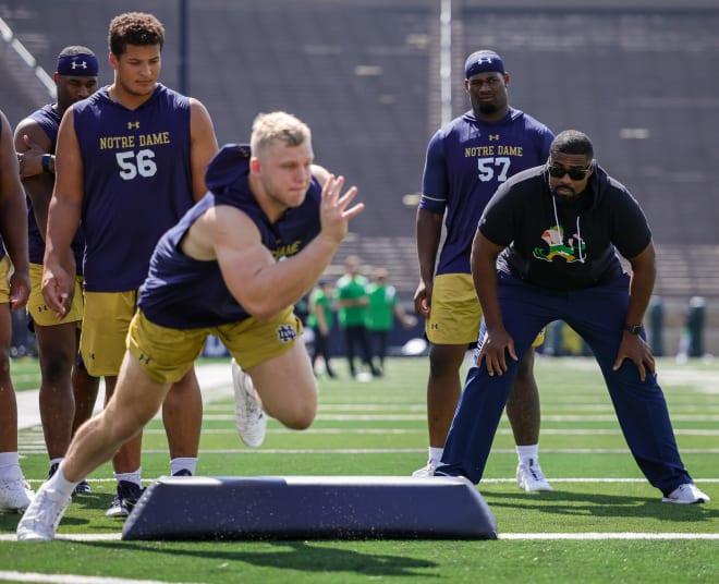 ND defensive line coach Al Washington (right) watches defensive end Rylie Mills run through a pregame drill on Saturday,